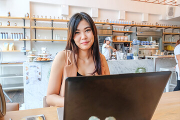 Fototapeta na wymiar Women typing on the laptop computer at modern coffee shop