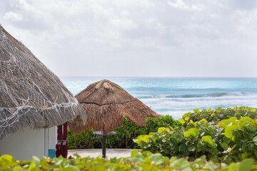 Fototapeta na wymiar Scenery from the paradise. Small house and umbrella on the shore.