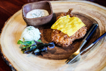 Fried chicken with slive cheese on wood dish