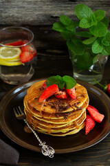 Pancakes with caramel and strawberries for breakfast.
