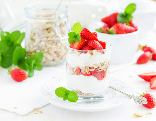 Dessert in a glass with granola, yogurt and strawberries. Useful breakfast.