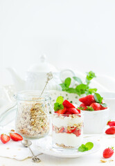 Dessert in a glass with granola, yogurt and strawberries. Useful breakfast.