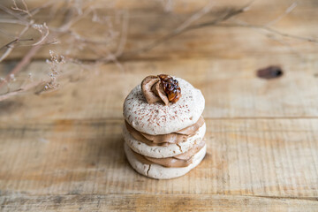 Beige macaroon cookie on wooden background