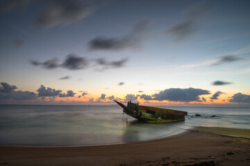 Sunrise view of beach with abandoned ship