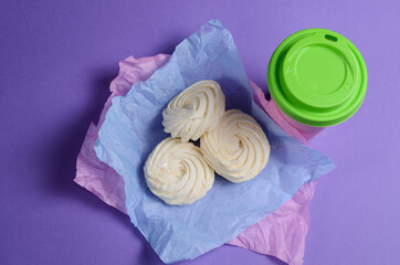 Food Photo of homemade zephyr, marshmallow in violet wrapping paper and coffee to go cup.