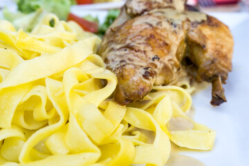 close-up of plate of pasta and chicken with lettuce
