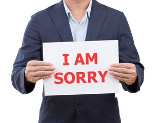 Businessman holding board with Sorry message on white background