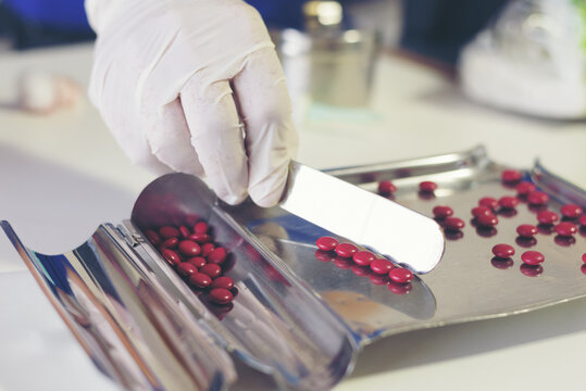 Counting tablets medical pills on stainless steel tray.Health care and medical concept