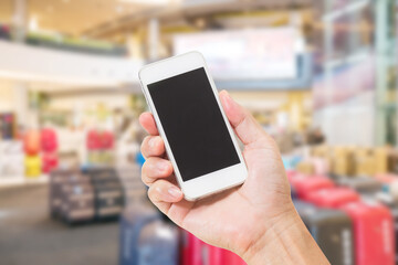 Hands holding mobile phone with blurred image of shopping mall