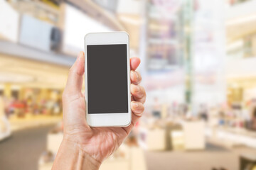 Hands holding mobile phone with blurred image of shopping mall