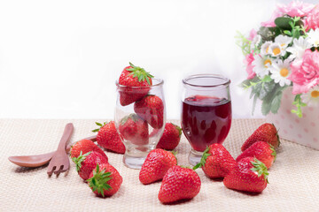 Fresh strawberries and strawberry jam in the glass  jar and strawberries in a wooden bowl
