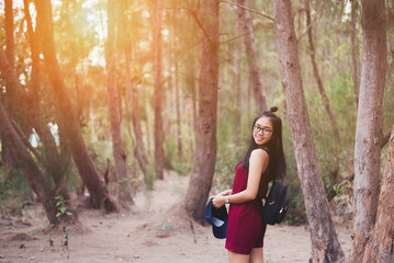 The girl smiled in a pine forest at  the summer season.Travel concept