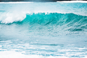 Blue wave in tropical ocean. Wave barrel crashing and clear water.