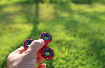 Man playing with Red fidget spinners outdoors popular toy