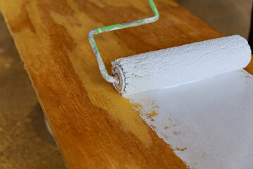 painting the wood with white paint roller