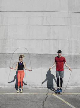 Woman and man jumping rope outdoors