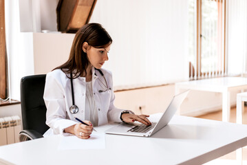 Medical doctor woman working on laptop in office