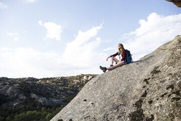 Spain, Madrid, young woman resting on a rock during a trekking day