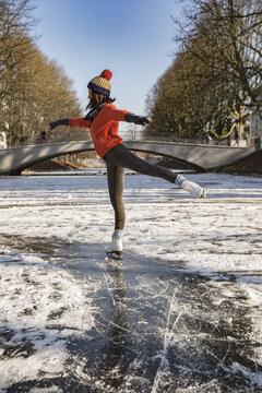 Woman ice skating on canal