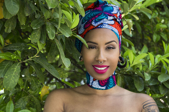 Portrait of smiling young woman with piercings wearing traditional Brazilian headgear