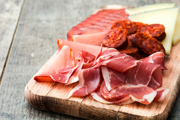 Spanish cold cuts (embutidos). Cheese, sausage and ham on wooden table
