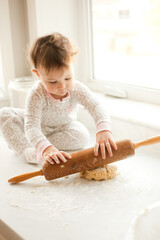 Small child baking cookies on marble counter in kitchen