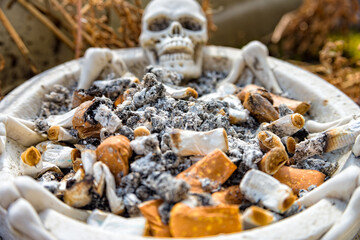 Skull ashtray with many cigarettes in this