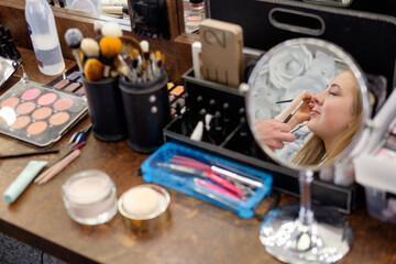 make up artist making makeup, mirror reflection