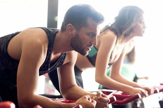 closeup image of man and woman doing spining exercises in a gym