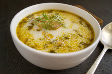 Salmon soup with cream, potatoes, carrots and dill. on a black background.