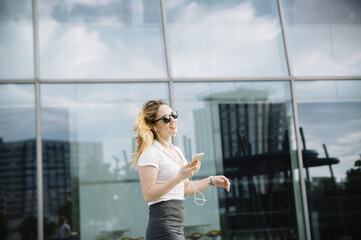 Young blond woman listening to music outdoors