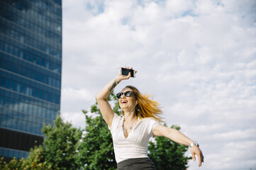 Young blond woman listening to music outdoors