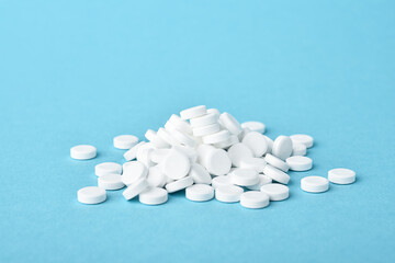 Weiße Tabletten vor blauem Hintergrund