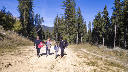 A group of people hiking through a forrest passage in Bansko, Bulgaria