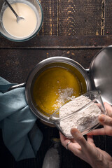 Preparation of veloute sauce on the wooden table  vertical