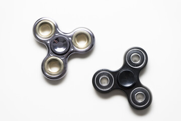 Blurred rotation of two fidget spinners relaxing toys on a white background.