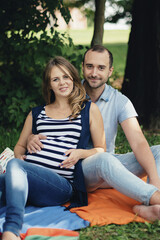 Fototapeta premium Man and pregnant woman, in an amorous couple in the park