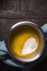 Broth with flour for veloute sauce on the wooden table vertical