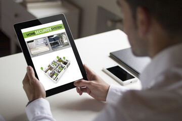 businessman viewing security cams with tablet pc