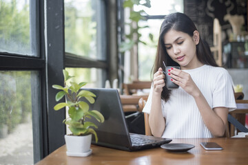 Obraz premium Beautiful business girl working with tablet , smartphone and drinking coffee in coffee shop