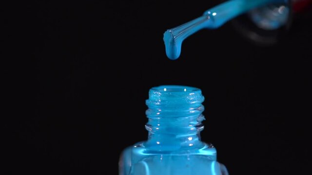 Clsoeup of a blue nail polish drpping into the bottle slow motion