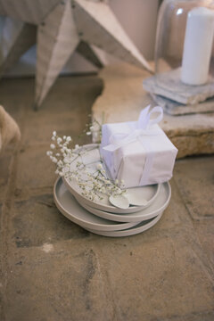 Assiettes blanches avec paquet cadeau et fleurs ambiance de Noel