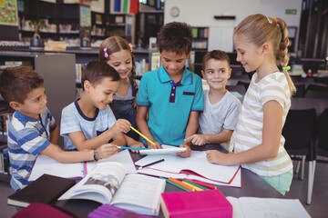 Attentive schoolkid using digital tablet in library