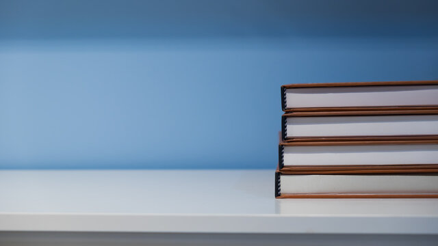 Books on the whte table and blue background