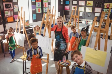 Teacher and schoolkid standing together in drawing class