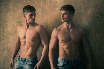 Fototapeta na wymiar men twins posing with strong, naked torso