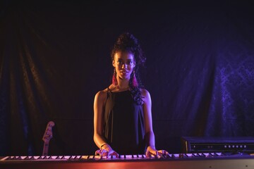 Female musician playing piano at popular music concert