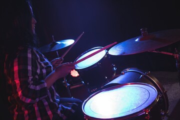 Fototapeta premium Female drummer practicing in nightclub