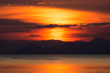 Fototapeta na wymiar Silhouettes of mountain with sunset at the lake, Thailand.