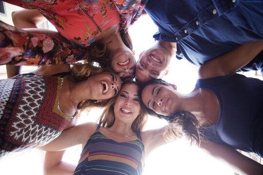 Gruppo di amici sorridenti nel cerchio - vista dal basso